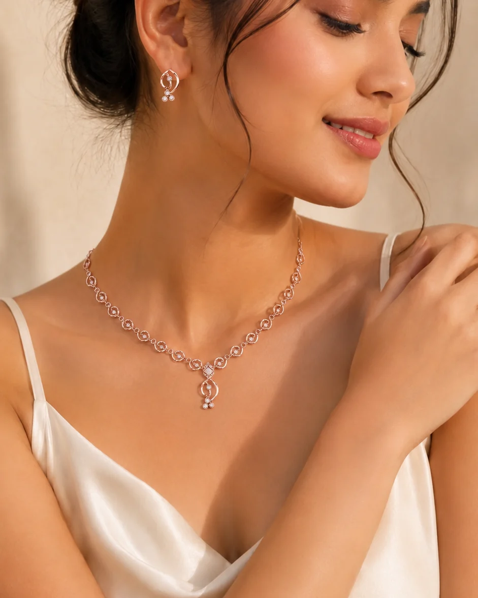 A fine gold diamond necklace and matching earrings worn on satin